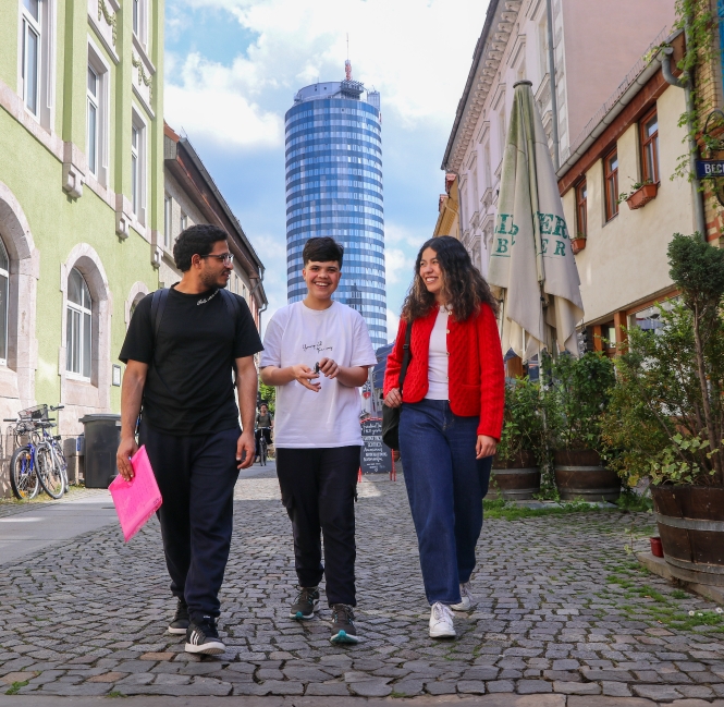 Junge Menschen erkunden eine malerische Straße mit historischen Gebäuden.